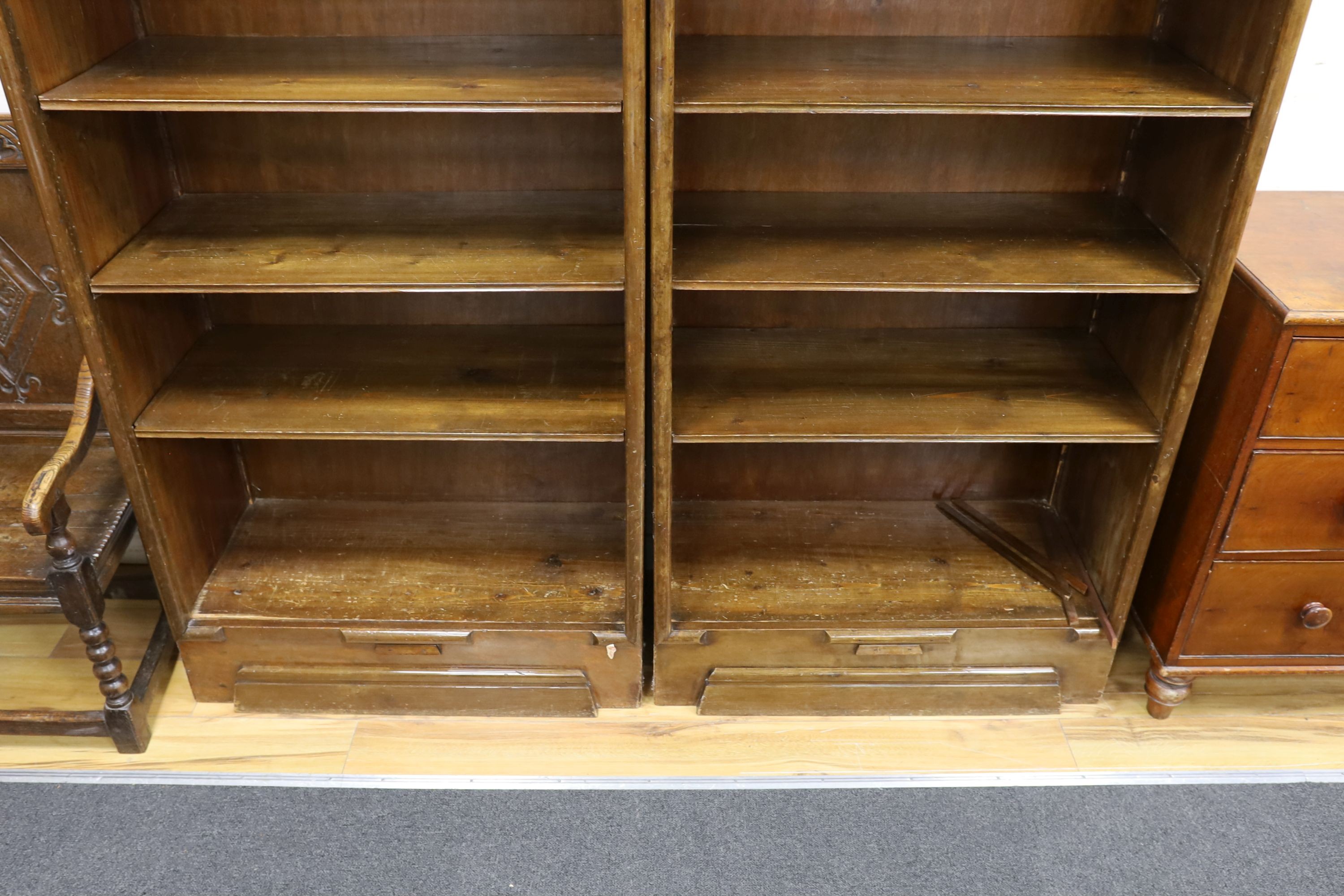 A pair of Hungarian mahogany and pine open fronted bookcases, with adjustable shelving, each width 89cm, depth 40cm, height 200cm